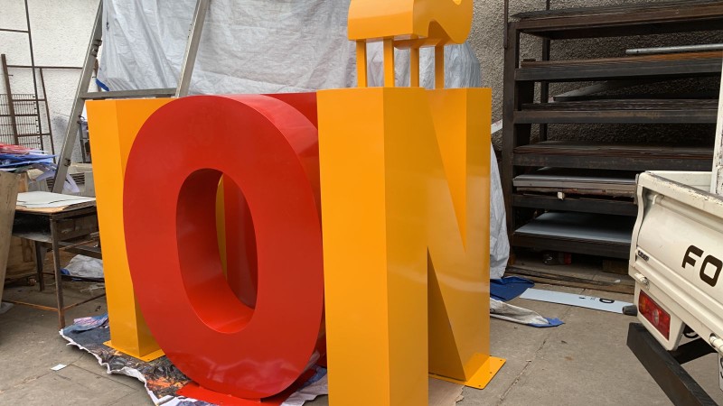 Fabricación de letras volumétricas de acero inoxidable con pintura electrostática en colores corporativos para letreros comerciales.